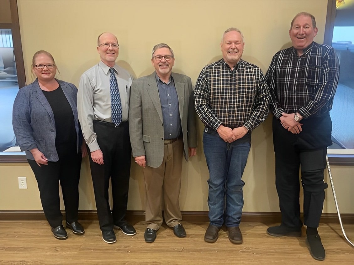 One Woman and Five Men Standing United in Office Setting.