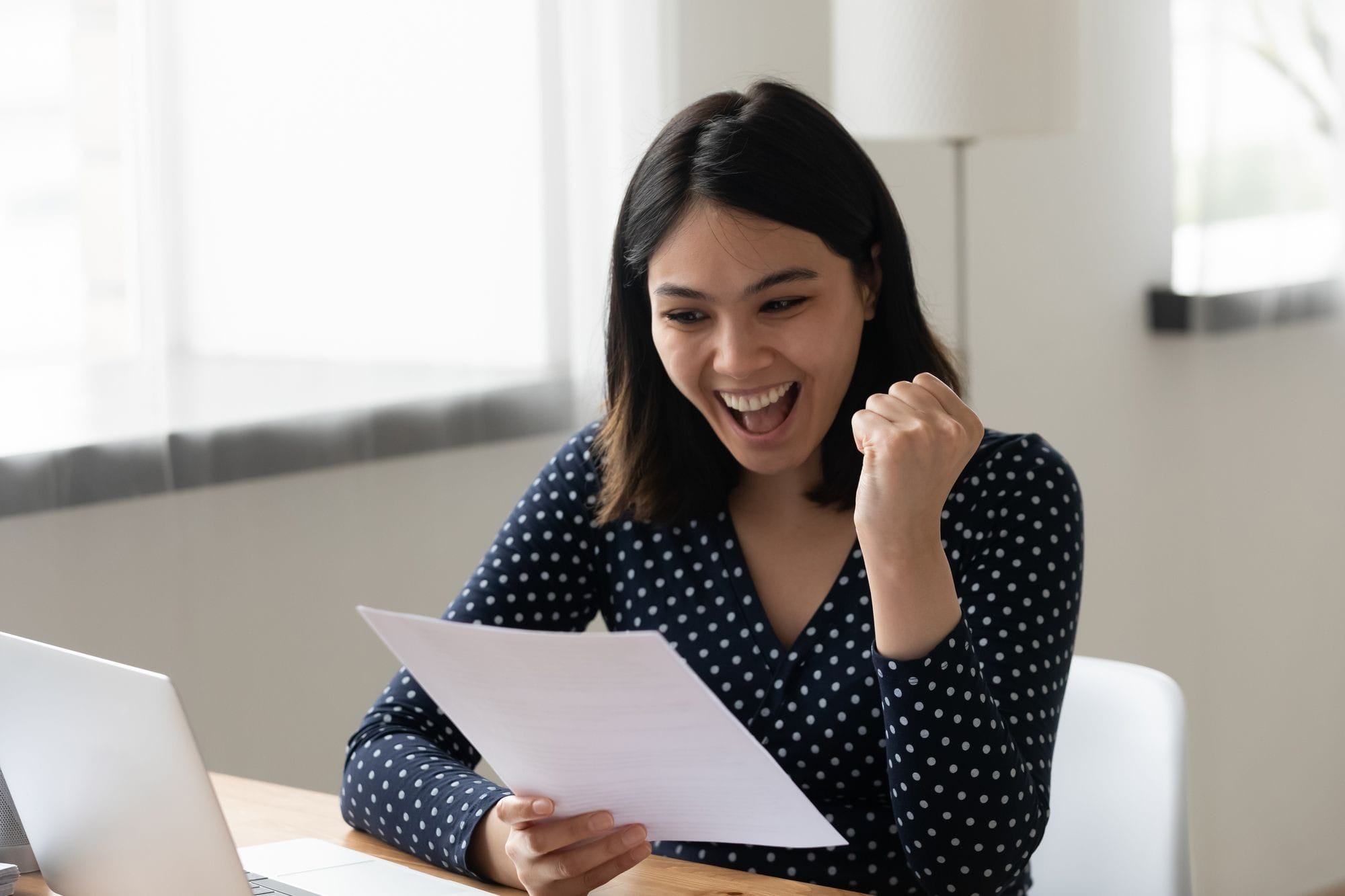 Lady at Desk With Paper and Laptop.